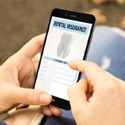 person looking at dental insurance information on cell phone 