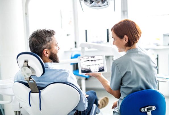 a patient speaking with his dentist about dental implants
