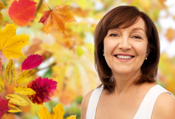 Older woman with All-on-4 dental implants in Everett, WA outside during autumn