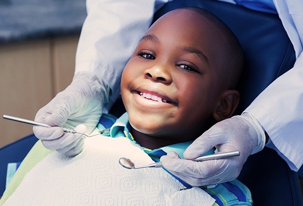 Boy in dental chair smiling during dental checkup
