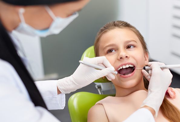 Girl receiving dental exam after pulp therapy