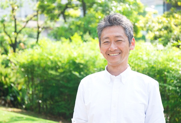 Older man with silver hair outside and smiling