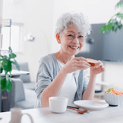 a woman with dentures enjoying a healthy meal