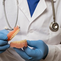 Dentist holding full dentures in Everett