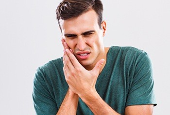 Man with knocked out tooth holding jaw
