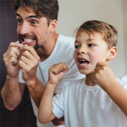 father and son flossing their teeth