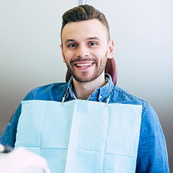 A young man showing off his smile after receiving a dental implant in Everett