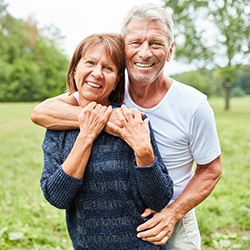 An older couple smiling after the woman received dental implants in Everett