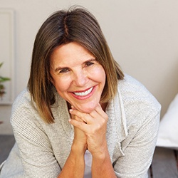 An older woman sitting outside and feeling confident about her dental implants in Everett