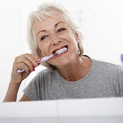 Woman brushing teeth in Everett