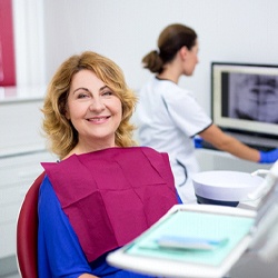Middle-aged woman smiling during her dental appointment