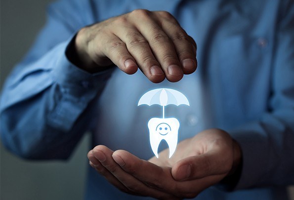 Hands holding animated tooth under umbrella