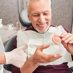 Male patient holding a denture