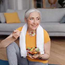 Older woman eating a salad with dentures
