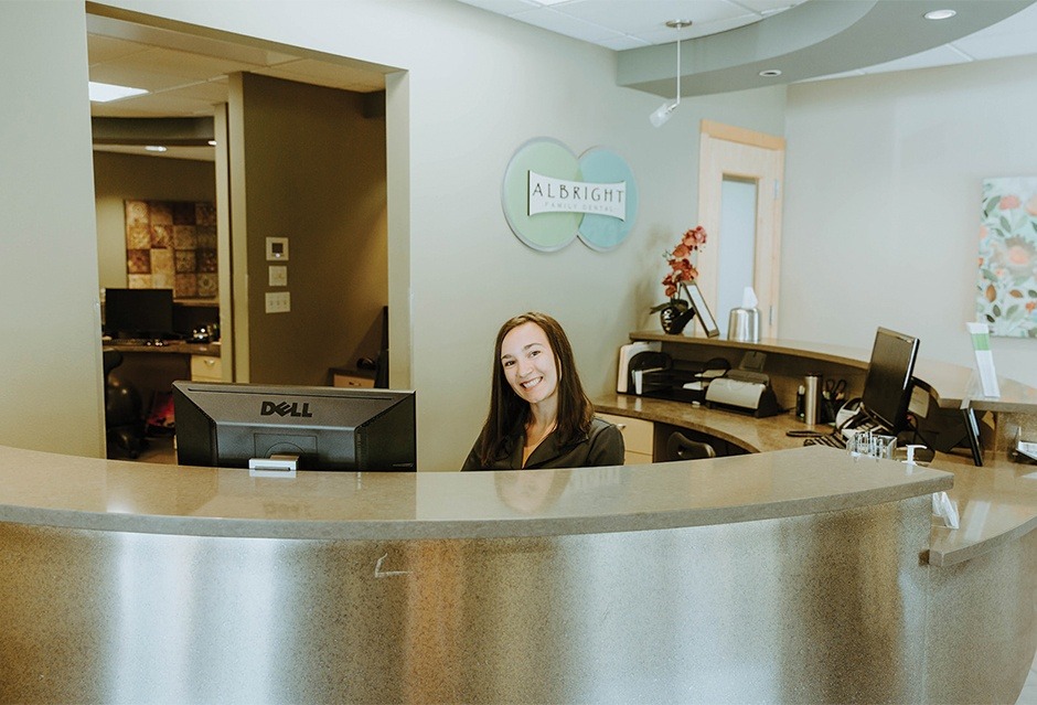 Smiling dental team member at reception desk