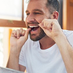 Man flossing his teeth