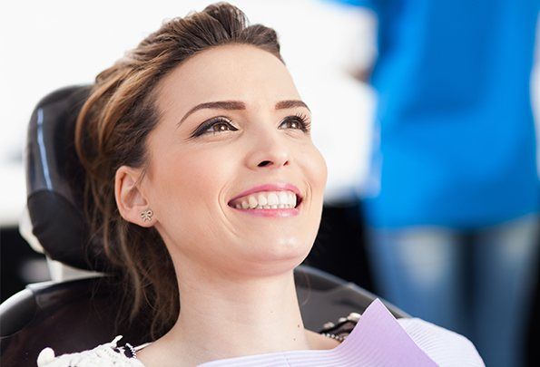 Woman in dental chair smiling during dental checkup