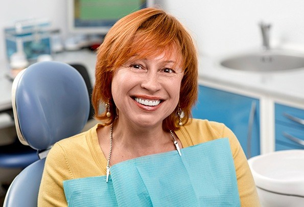 Smiling older woman in dental chair after root canal therapy