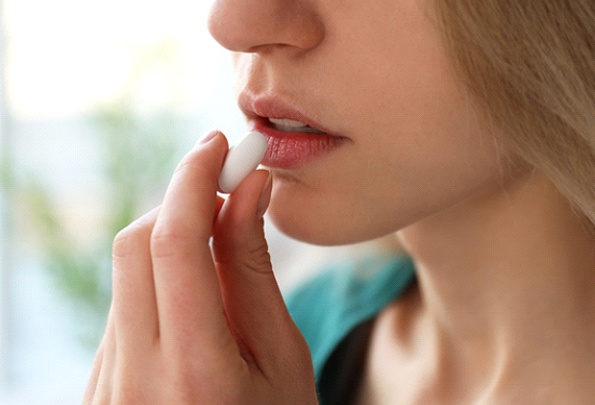 An up-close view of a woman preparing to take a prescribed oral medication to undergo the effects of sedation for a dental procedure in Everett