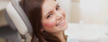 Smiling woman in dental chair after preventive dentistry visit