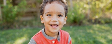 Smiling boy outdoors after chilren's dentistry visit