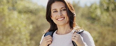Smiling woman outdoors after restorative dentistry
