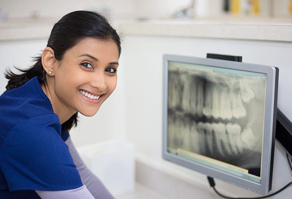 Dental team member looking at digital x-rays