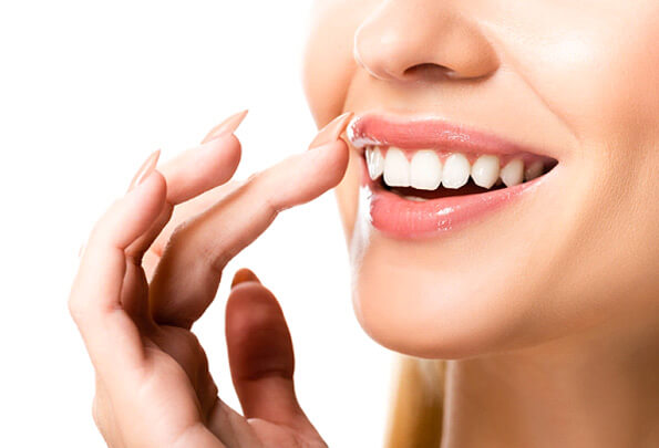 nose to chin view of woman touching her smile gently with her fingers