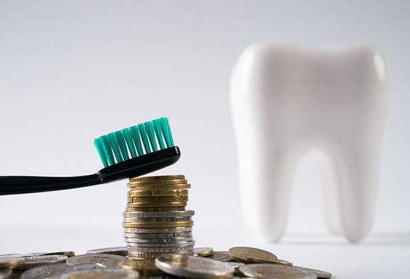 Tooth next to a pile of coins
