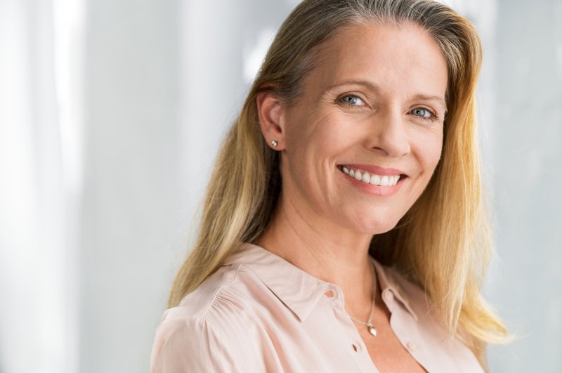 an older woman smiles after receiving her dental implants in Everett