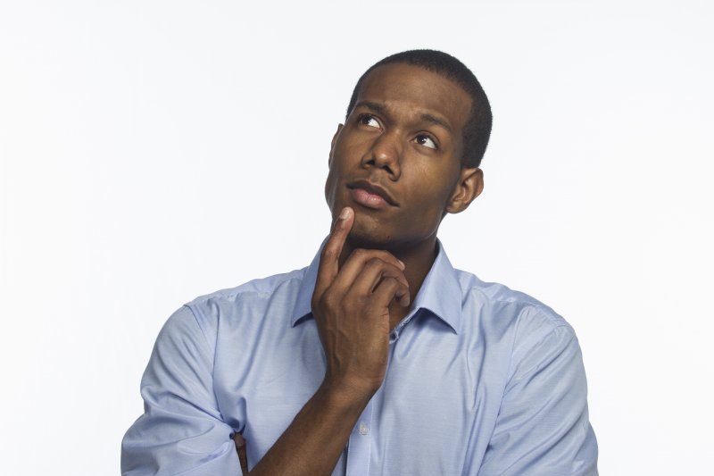 man thinking about what questions to ask his cosmetic dentist in Everett