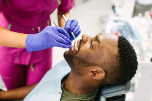 a man getting an oral cancer screening during his biannual exam