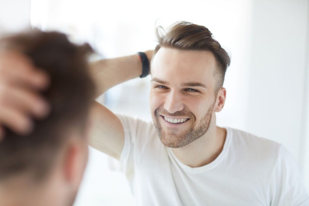 A man looking in the mirror at his smile