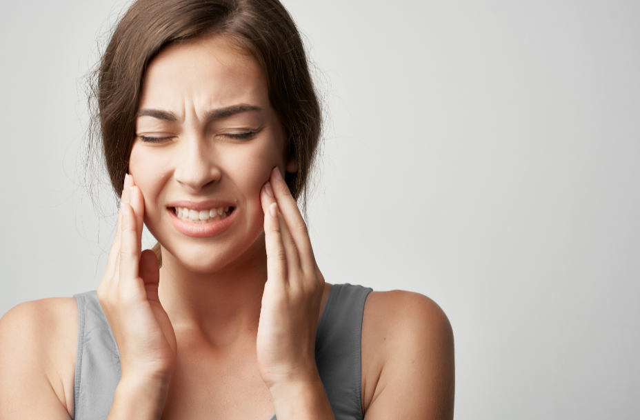 Woman holding her cheeks in pain