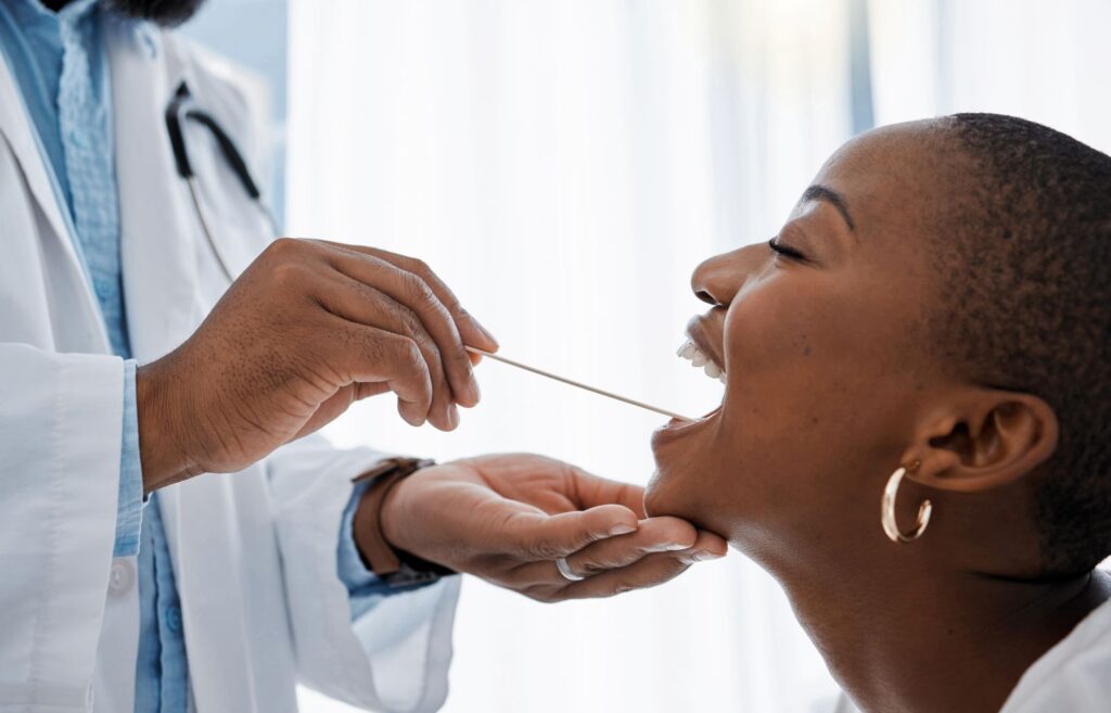 A woman getting an oral cancer screening from her dentist.